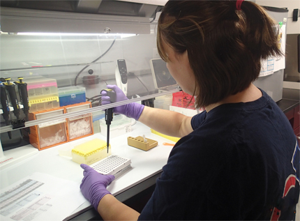 Lab technician with pipette and test tubes