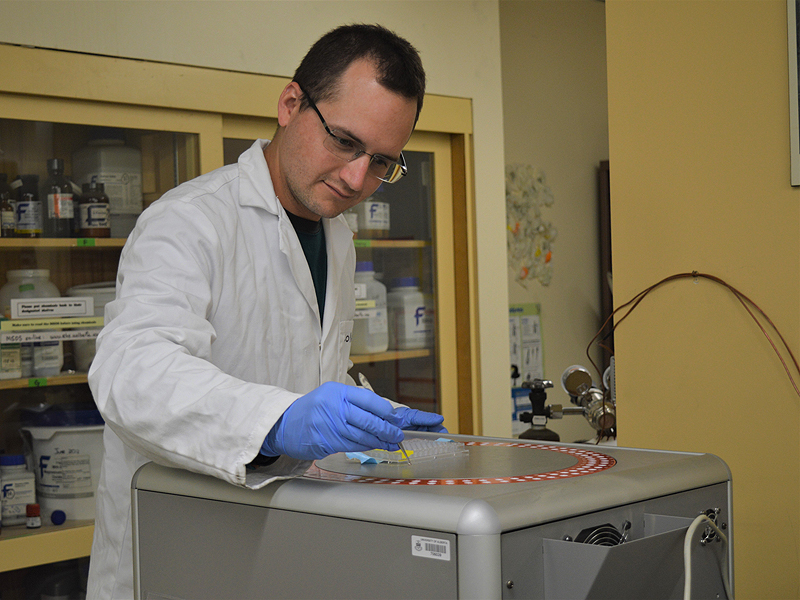 Scientist placing soil into elemental analyzer