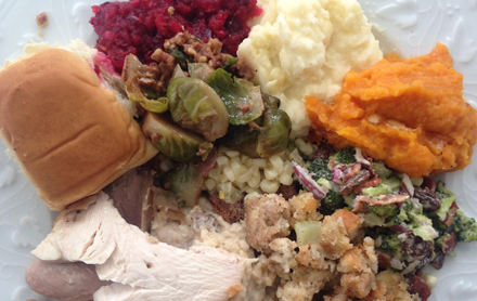 Thanksgiving meal with cranberries, turkey, sweet potatoes