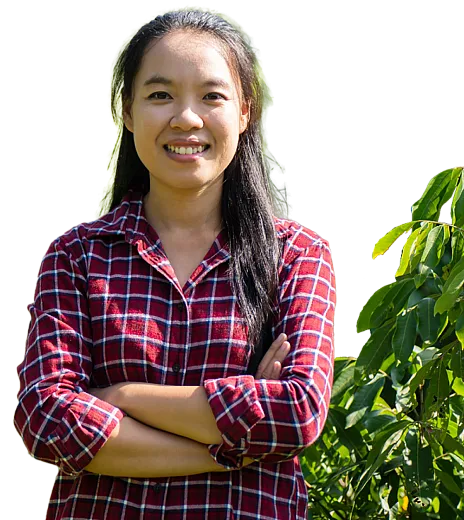 Woman with folded arms standing next to crops